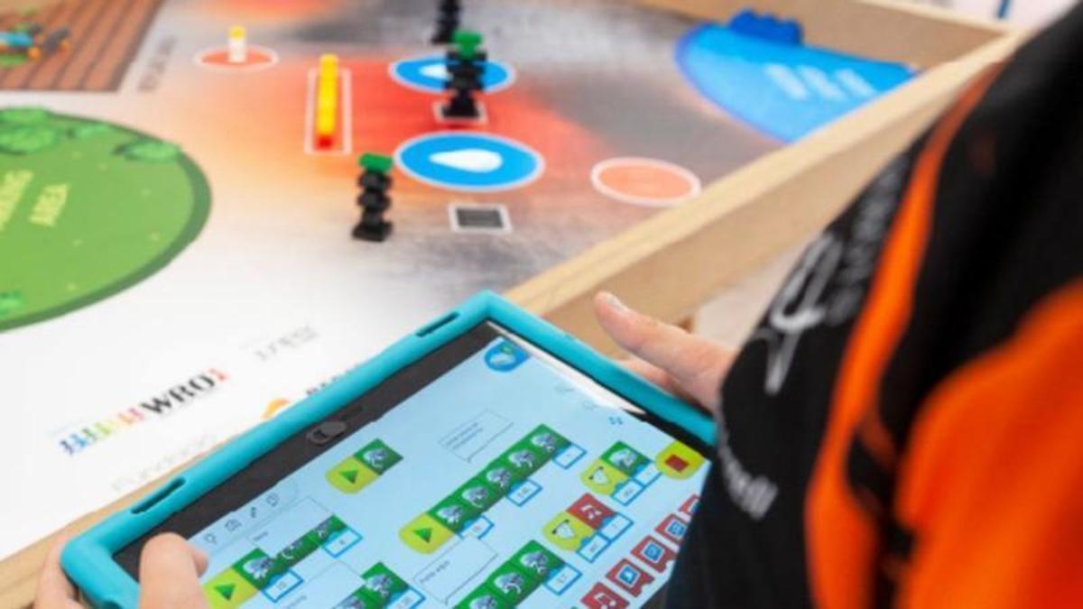 Un operario maneja una tablet con los comandos de un robot.
