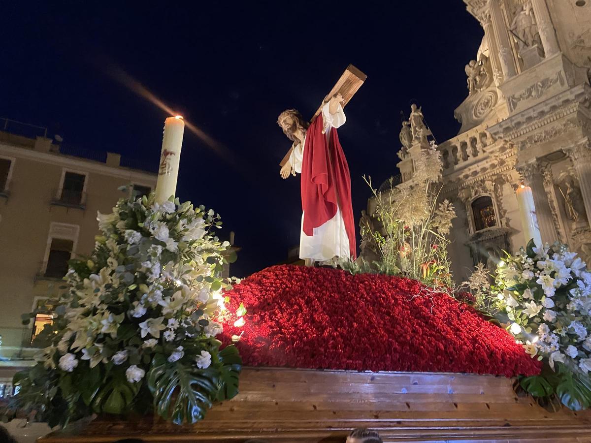 El Santísimo Cristo de la Esperanza de Alcantarilla, vestido de blanco y rojo, cargando el Madero a su espalda.