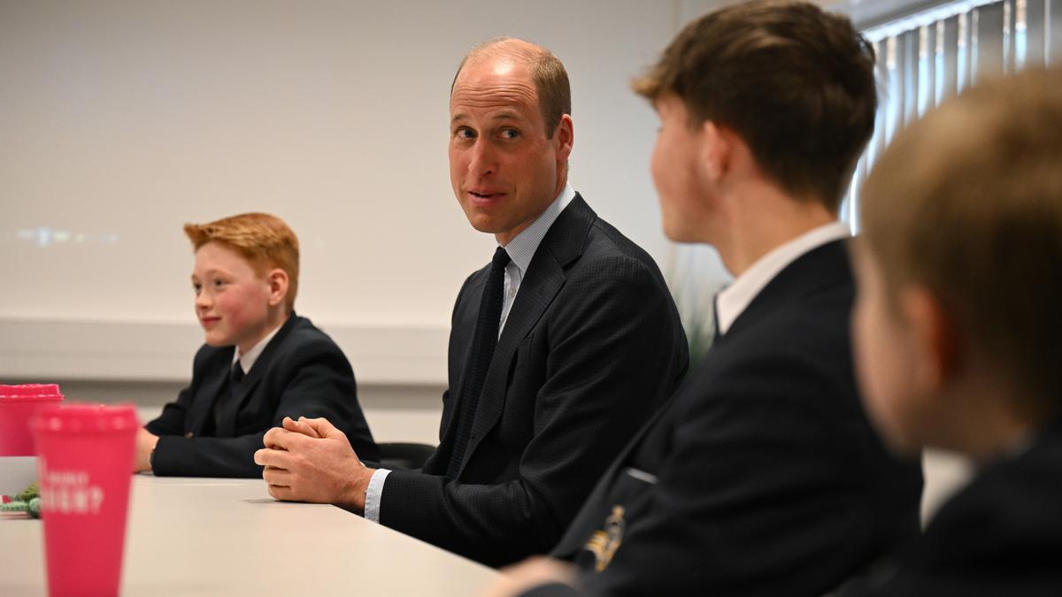 El príncipe Guillermo sentado con alumnos del colegio St. Michael's