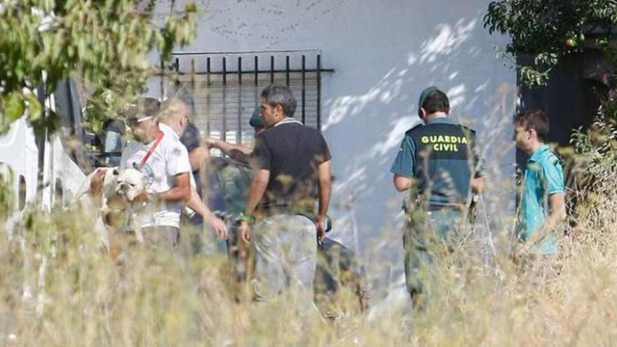 Los agentes del Seprona se incautan de los perros a las puertas de la finca denunciada. Un trabajador de Scooby recoge uno de los animales.