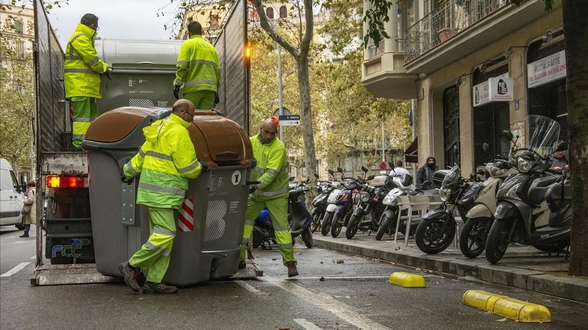 Operarios del Ayuntamiento colocan nuevos contenedores en la calle de Roger de Flor, esta mañana