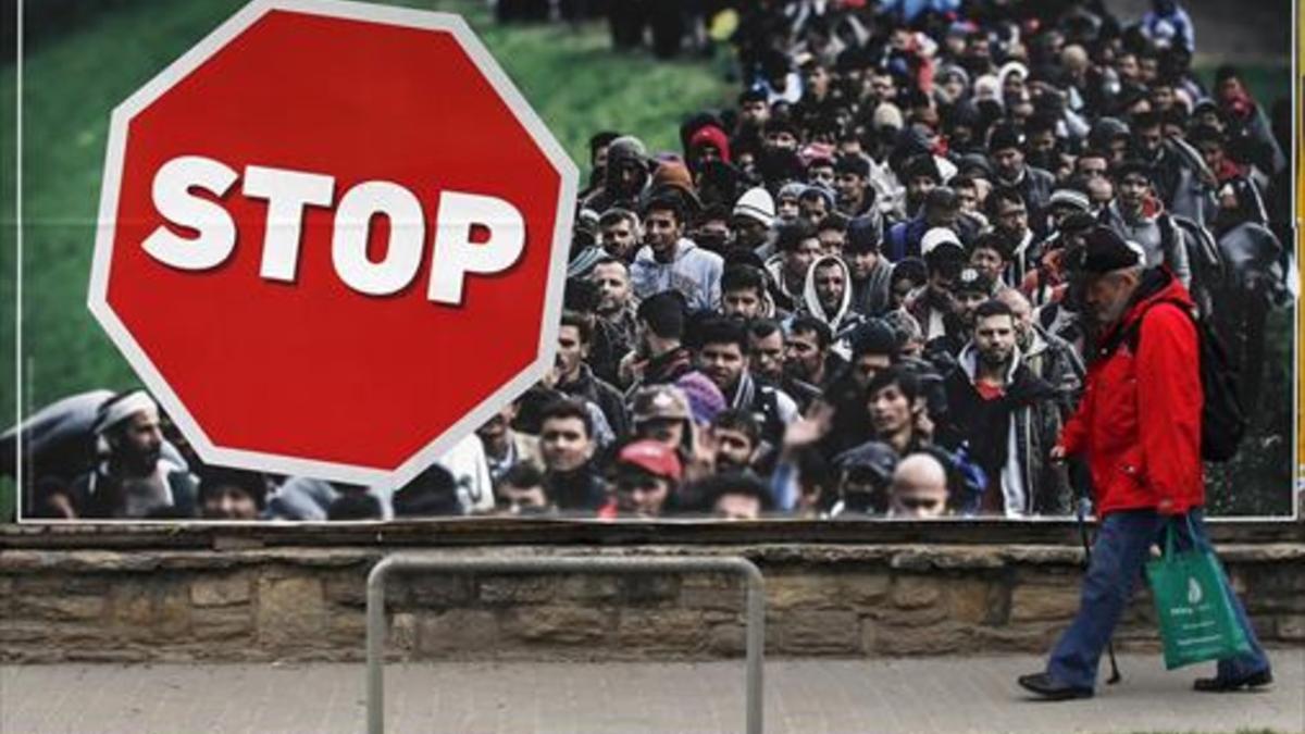 Un hombre, junto a un cartel contra la inmigración, ayer en Budapest.