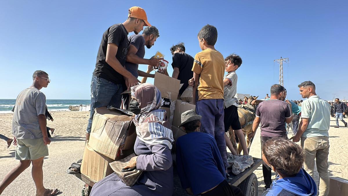 Palestinos acuden a un punto de reparto de ayuda en Rafá, en el sur de la Franja de Gaza