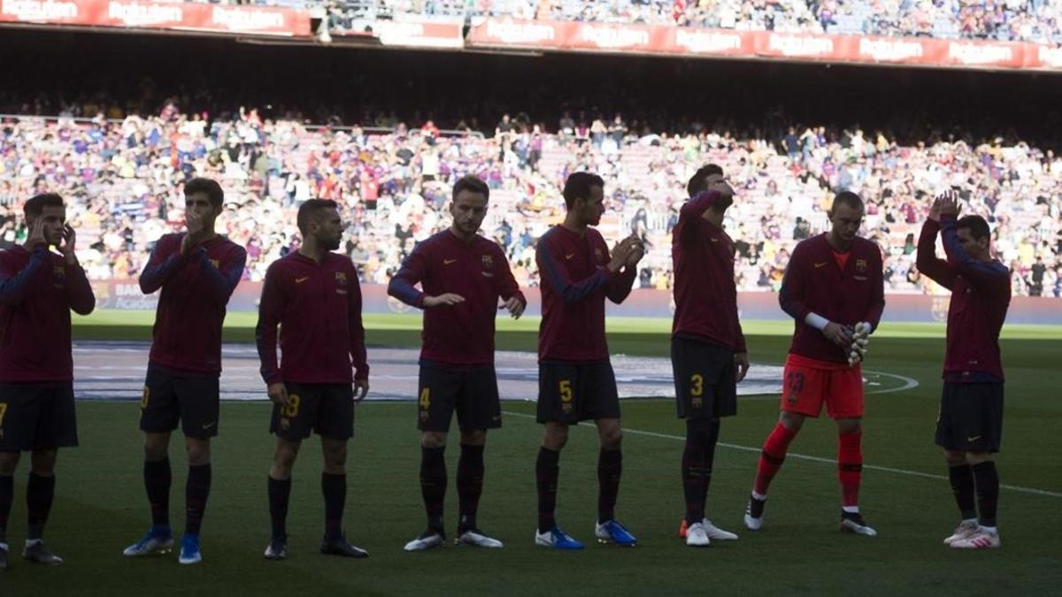 El equipo del Barça, en la sombra, saluda al Camp Nou.