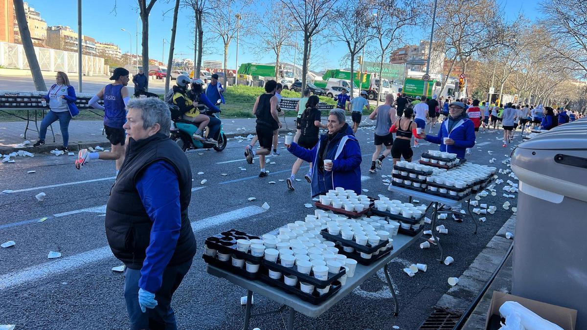 Pili Moreno dando vasos de agua en el km 10 del Maratón de BCN.
