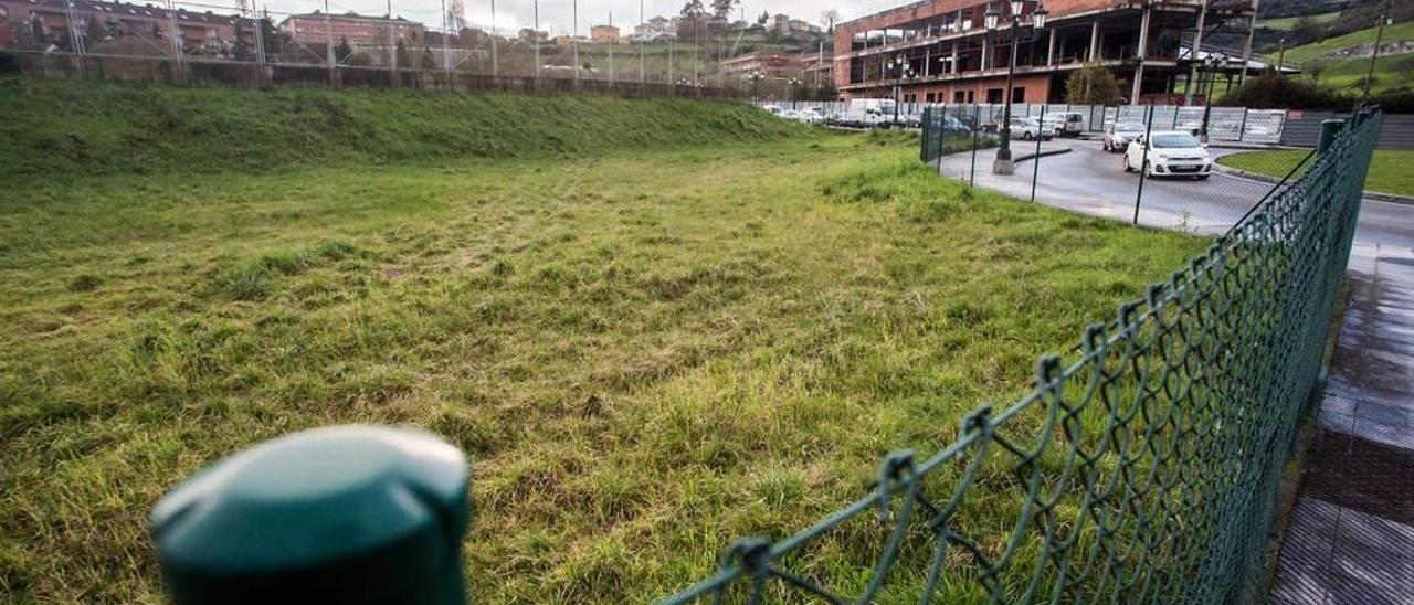 Terrenos en los que se construirá el complejo deportivo, con el fallido spa del Naranco al fondo.