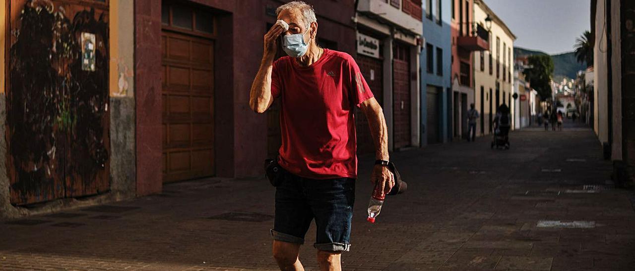 Un hombre pasea por la calle secándose el sudor que le provoca el calor de la jornada.