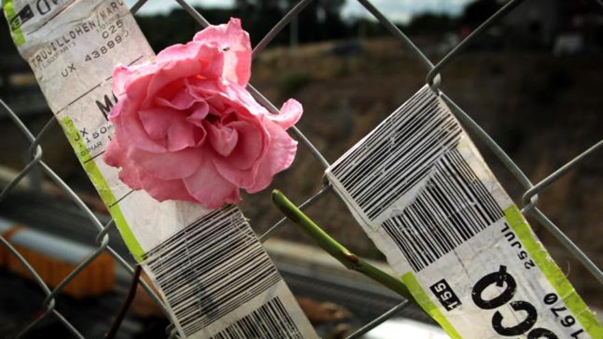 Una flor junto a unos billetes de tren en recuerdo a las víctimas.