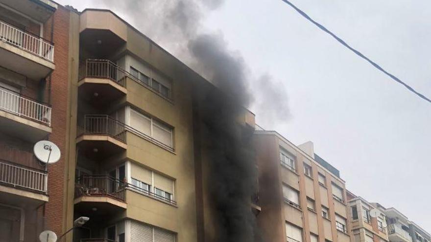 Els Bombers treballant per apagar l&#039;incendi originat en un taller mecànic a la Via de Sant Ignasi