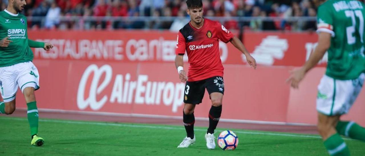 Joan Oriol conduce el balón durante el partido ante el Huesca en el Iberostar Estadio.