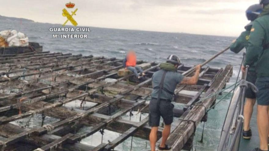 Un guardia civil llega al náufrago encaramado a una batea.