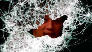 Un empleat del centre comercial més popular de Bangkok treu el cap per una finestra trencada.