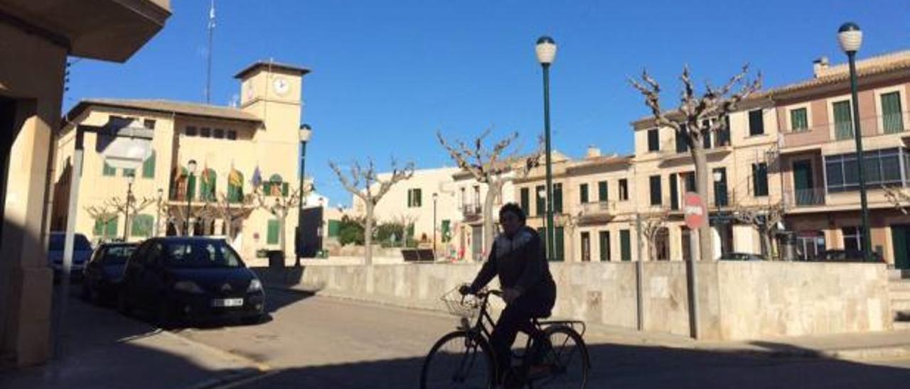 Una vecina circula ante la plaza Major y el ayuntamiento de ses Salines.