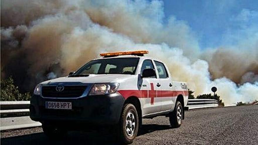 Un vehicle de la Creu Roja, a prop d&#039;una gran columna de fum