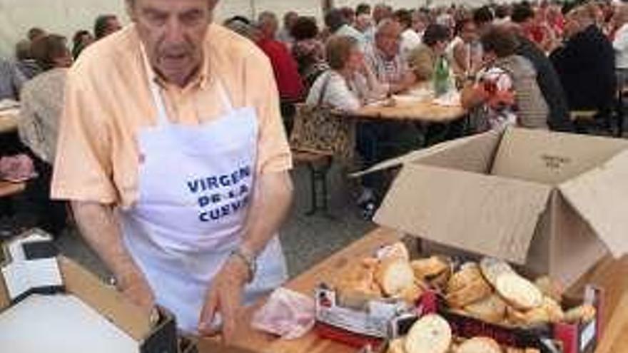 En la imagen superior, un grupo de pensionistas de Piloña disfruta de la parrillada en La Reboria. En el círculo, un voluntario reparte pan.