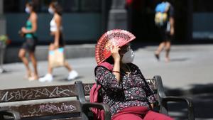Ola de calor, una señora se protege del sol en las Ramblas