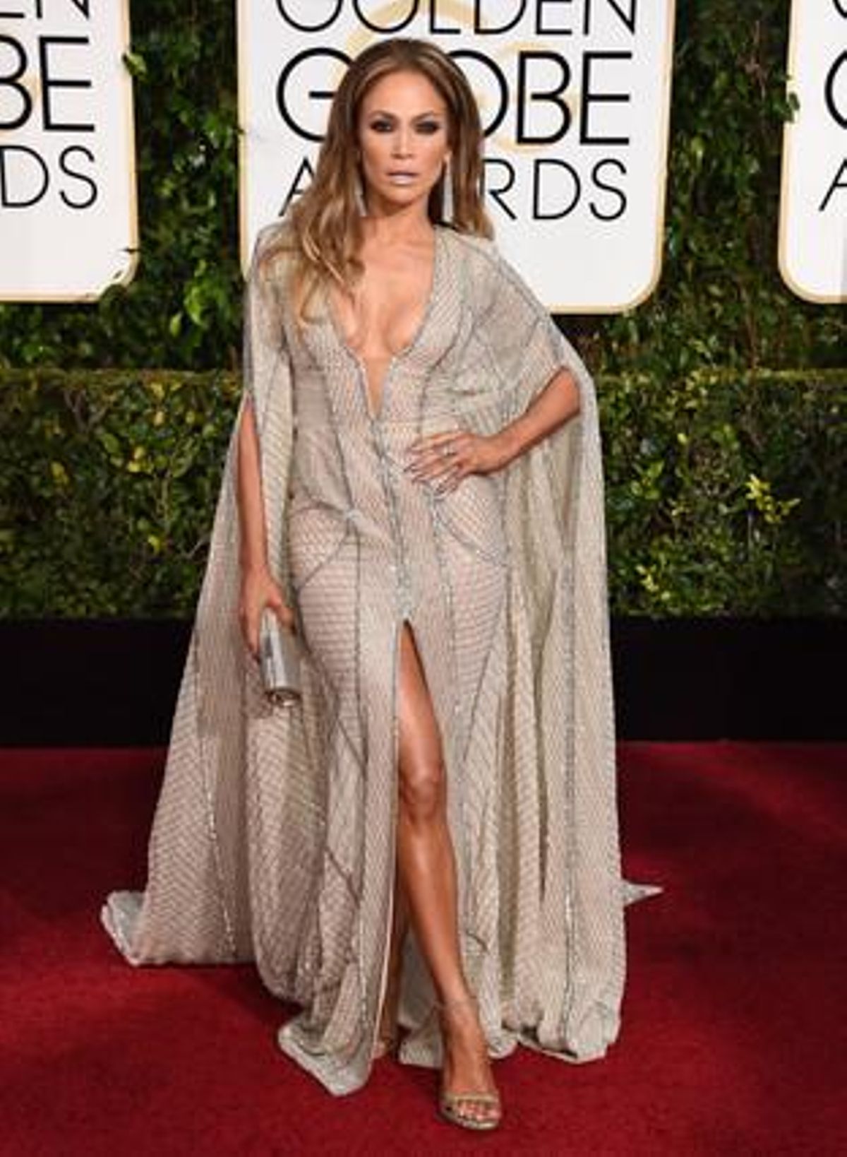 Jennifer Lopez, molt sensual amb un model en ’camel’ amb pedreria, capa i obertura lateral.