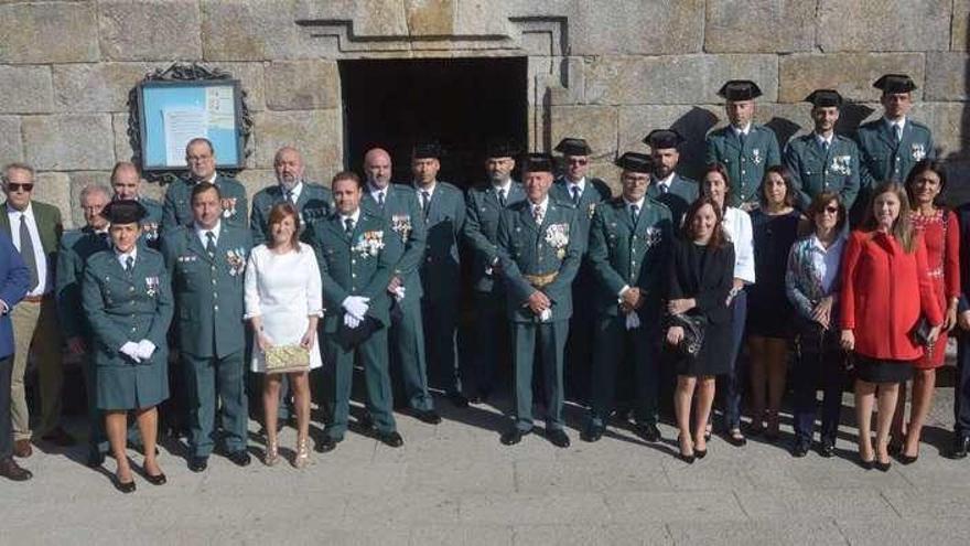 Los agentes, vestidos de gala, acompañados por miembros de la sociedad cambadesa, en el atrio de la iglesia, antes de la misa. // Noé Parga