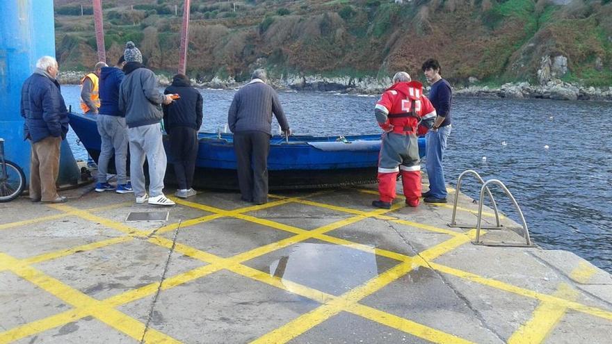 Los servicios de emergencias y varios pescadores revisan el estado de la embarcación naufragada. // FdV