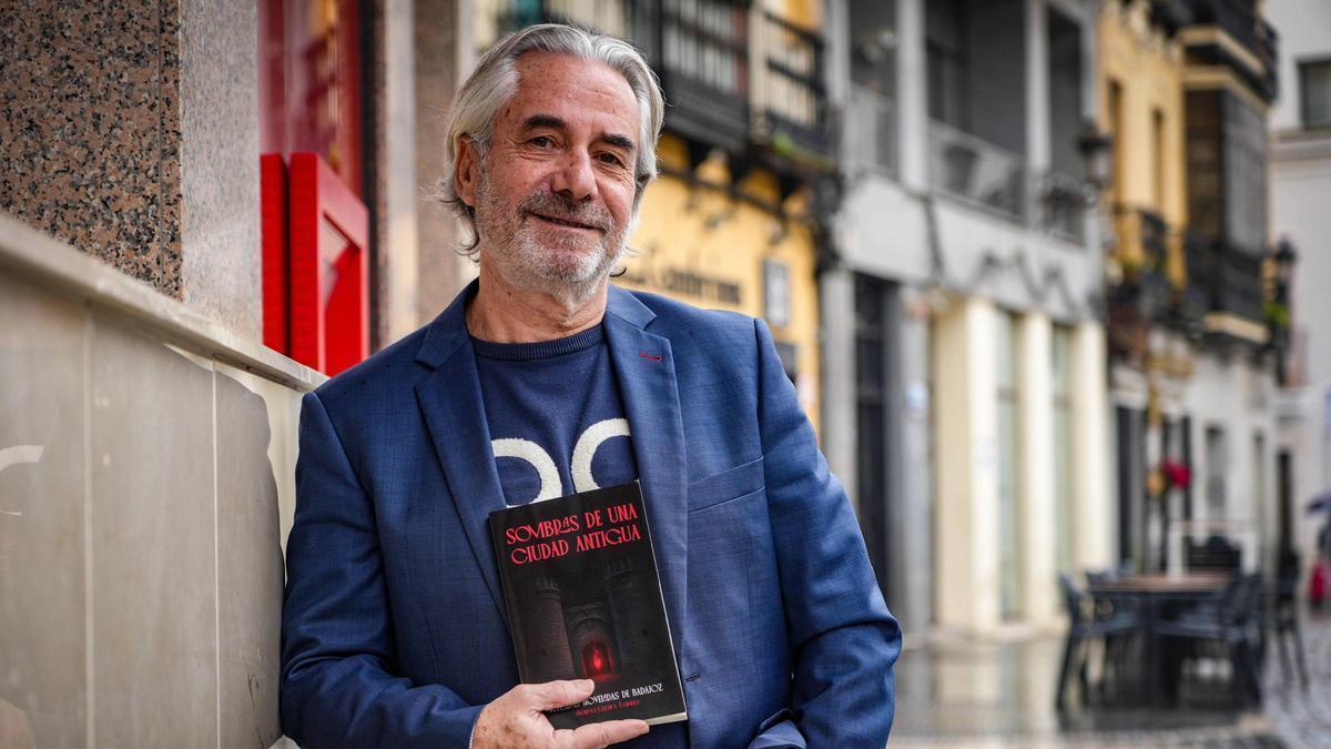 Juanma Cuesta posa con su último libro, Sombras de una ciudad antigua, en la plaza de España de Badajoz.