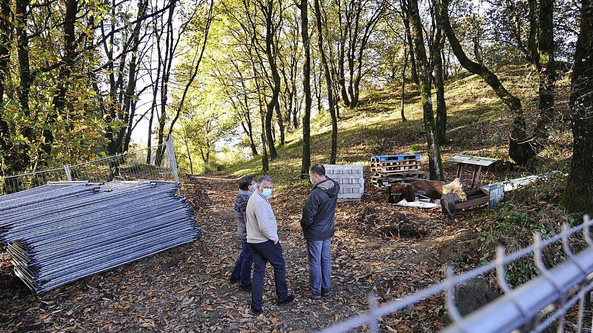 El alcalde y un técnico municipal departen con el arqueólogo de la empresa a la entrada del castro, junto a las viejas estructuras hormigonadas criticadas por la Diputación.   | // BERNABÉ/JAVIER LALÍN