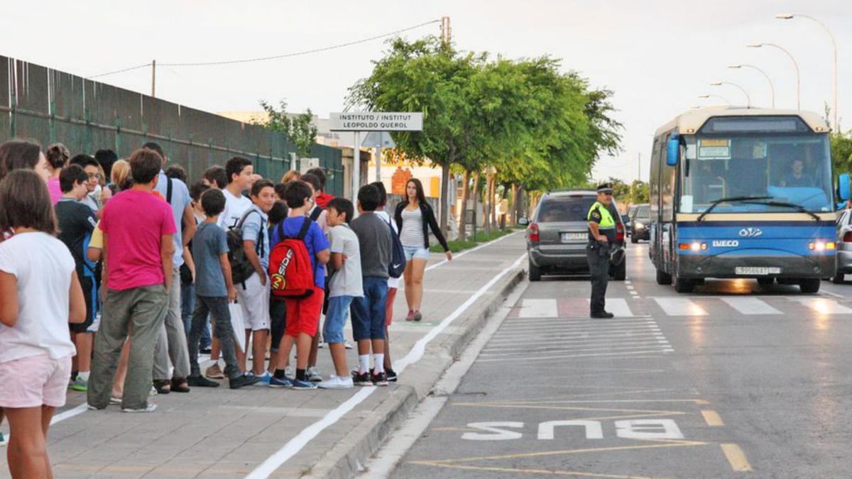 Imagen de unos alumnos esperando para subir en el autobús escolar.   | FLORES