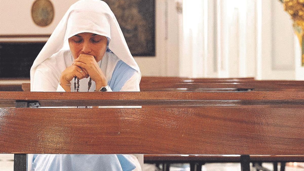 Ser comunicadoras en el siglo XXI no está reñido con conservar las tradiciones: una joven hermana reza, rosario en mano, en el templo
