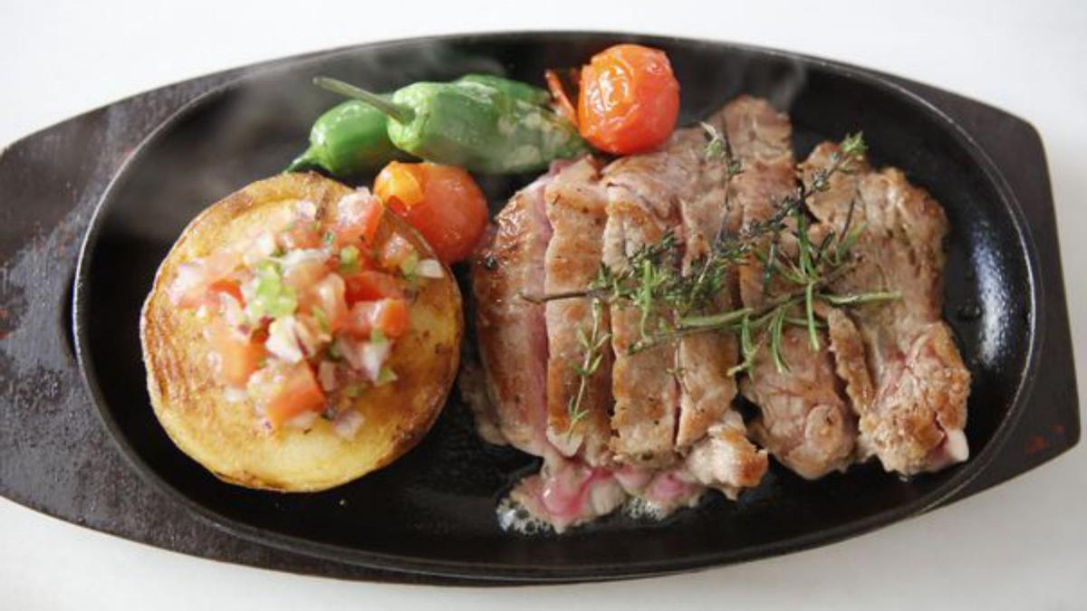 Entrecôte mit Backkartoffel und Tomatensalat. 