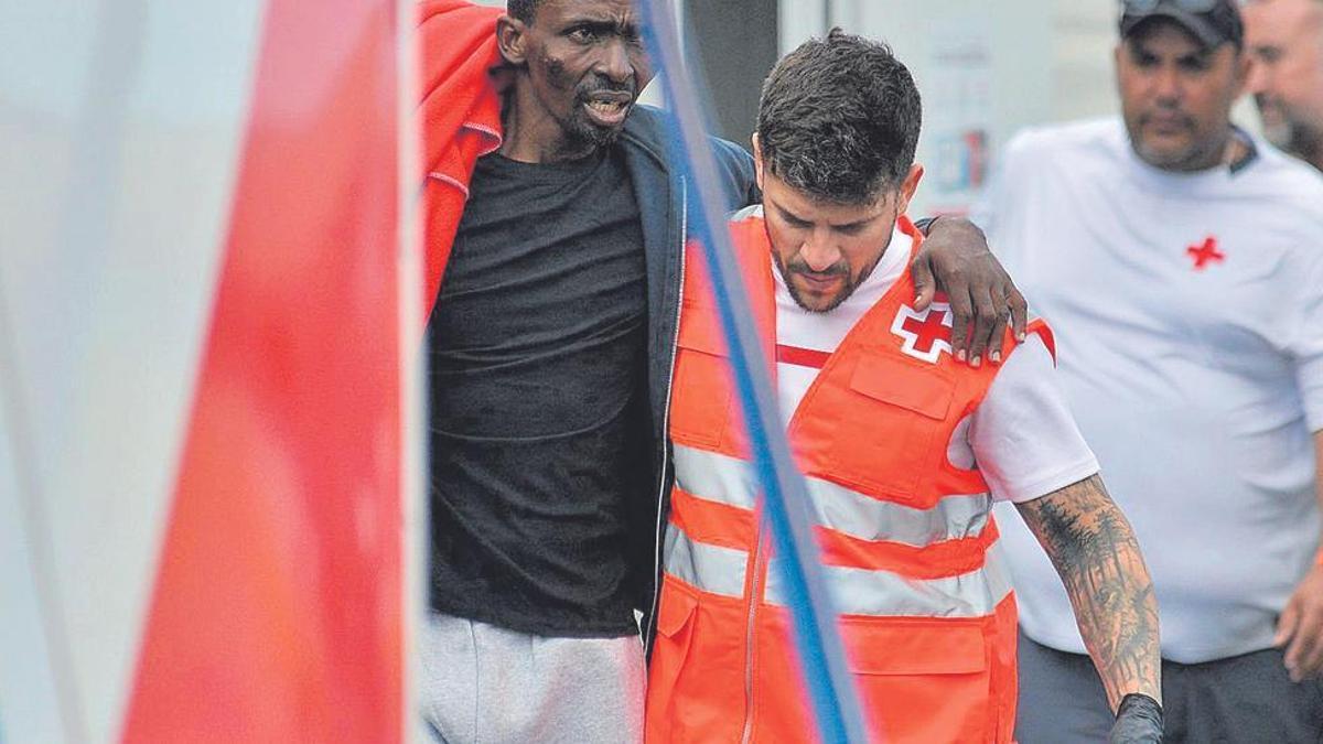 Un migrante rescatado por Salvamento Marítimo es atendido por los servicios médicos.