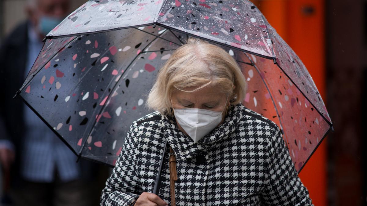 Una mujer con mascarilla por la calle.