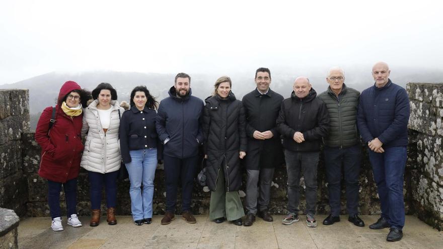 Nava Castro, diputada de Turismo y alcaldesa de Ponteareas, y Luis López, presidente de la Diputación, ambos en el centro, con representantes de los concellos de la comarca, ayer, en el castillo de Sobroso.