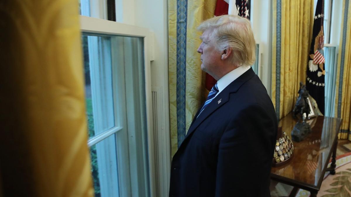 Trump mira por una ventana del Despacho Oval durante la entrevista con motivo de sus 100 días en la Casa Blanca.