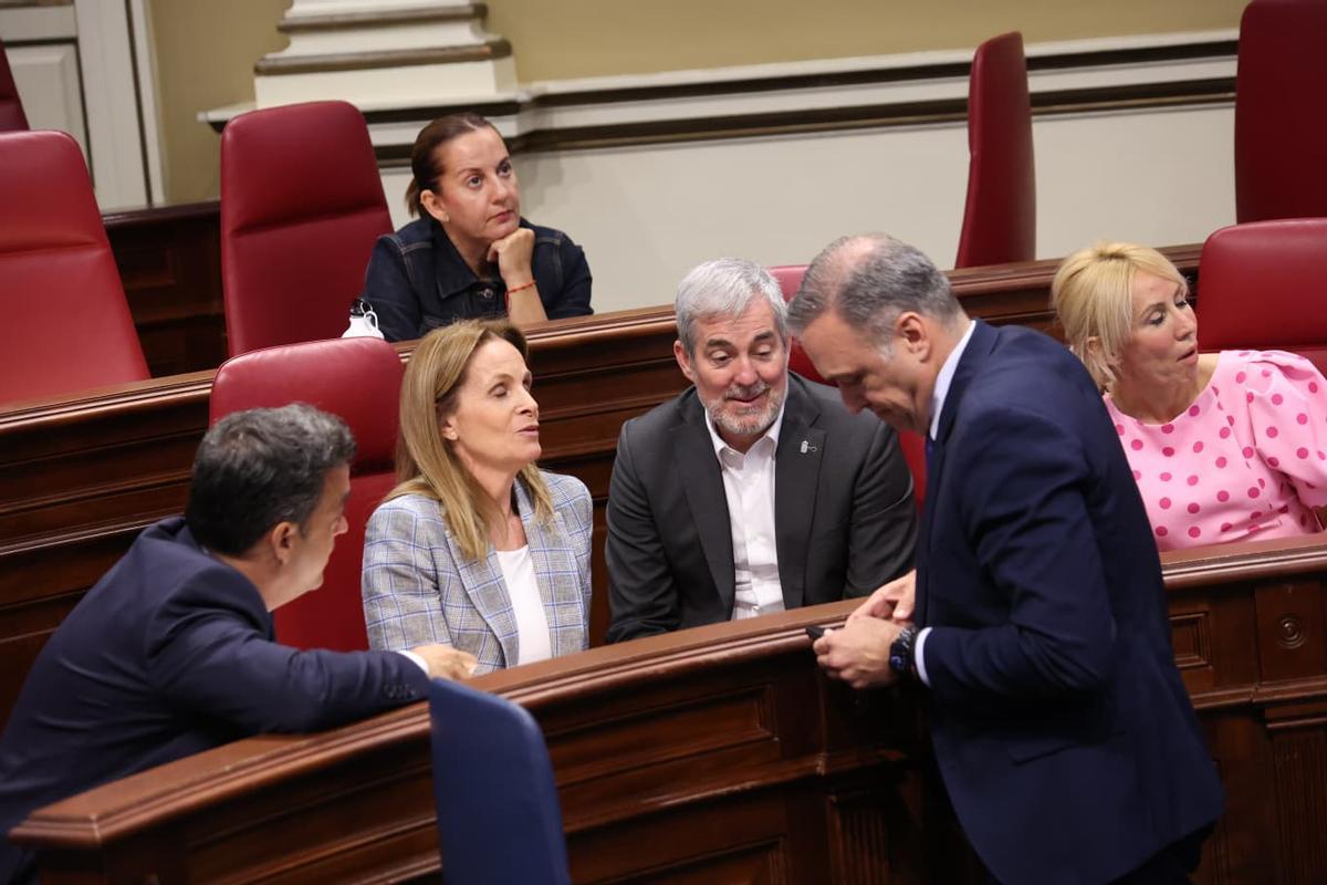 El presidente Fernando Clavijo sentado en los escaños de sus socios del PP conversa con los principlaes dirigentes del Grupo Popular.
