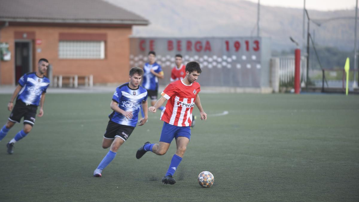 Partit al camp de futbol de Berga amb els vestidors al fons