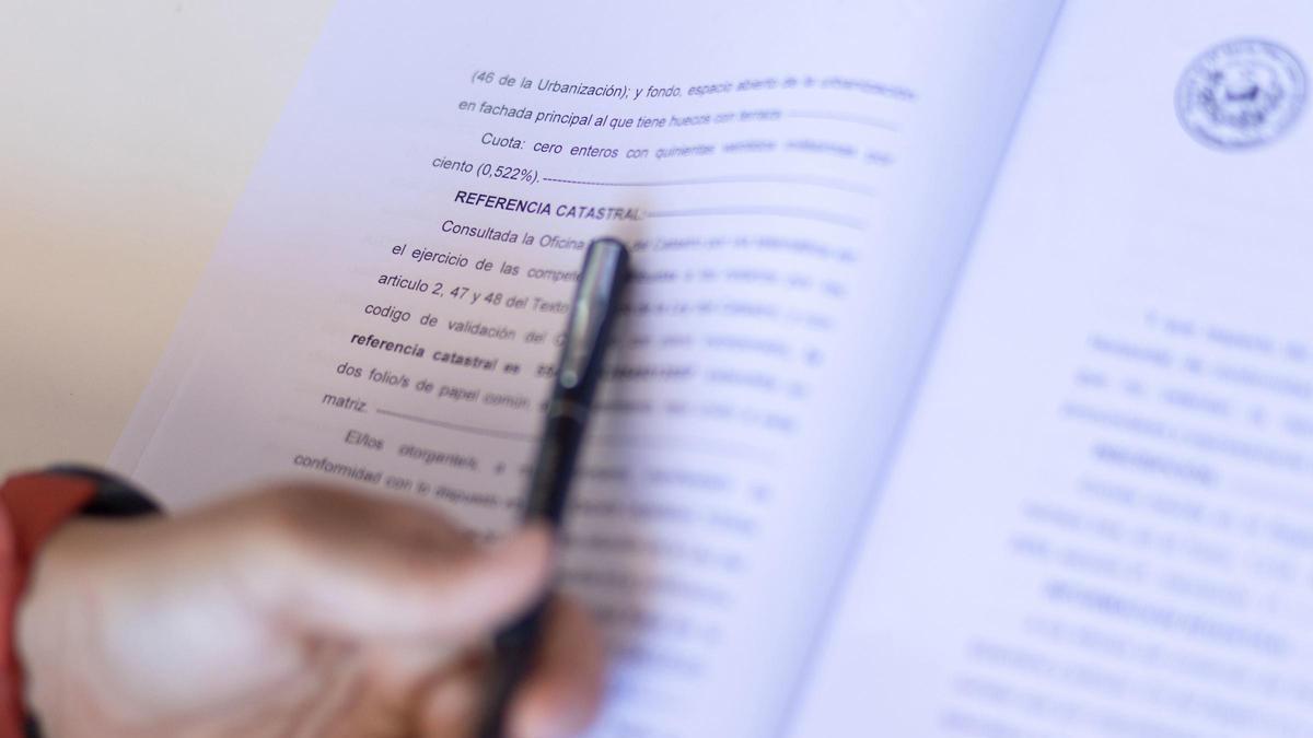 Una mujer señala una escritura de compraventa de una hipoteca