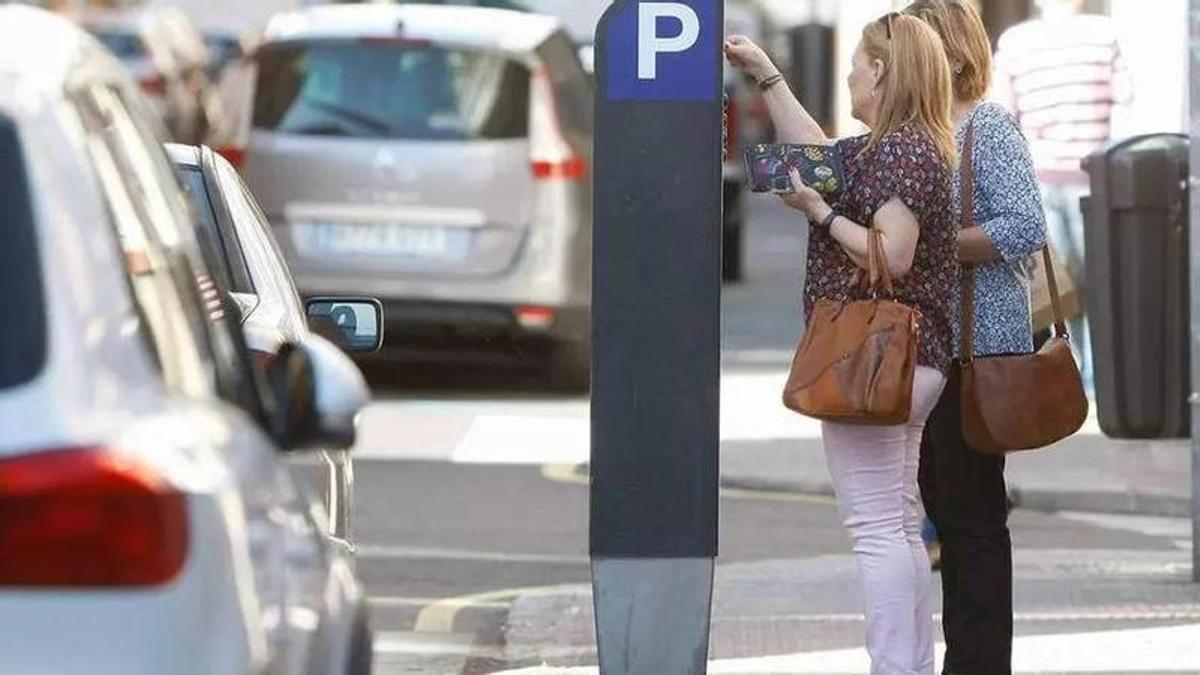 Dos zamoranas sacan un tiket para la ORA en una máquina de zona azul de las primeras instaladas en Zamora.