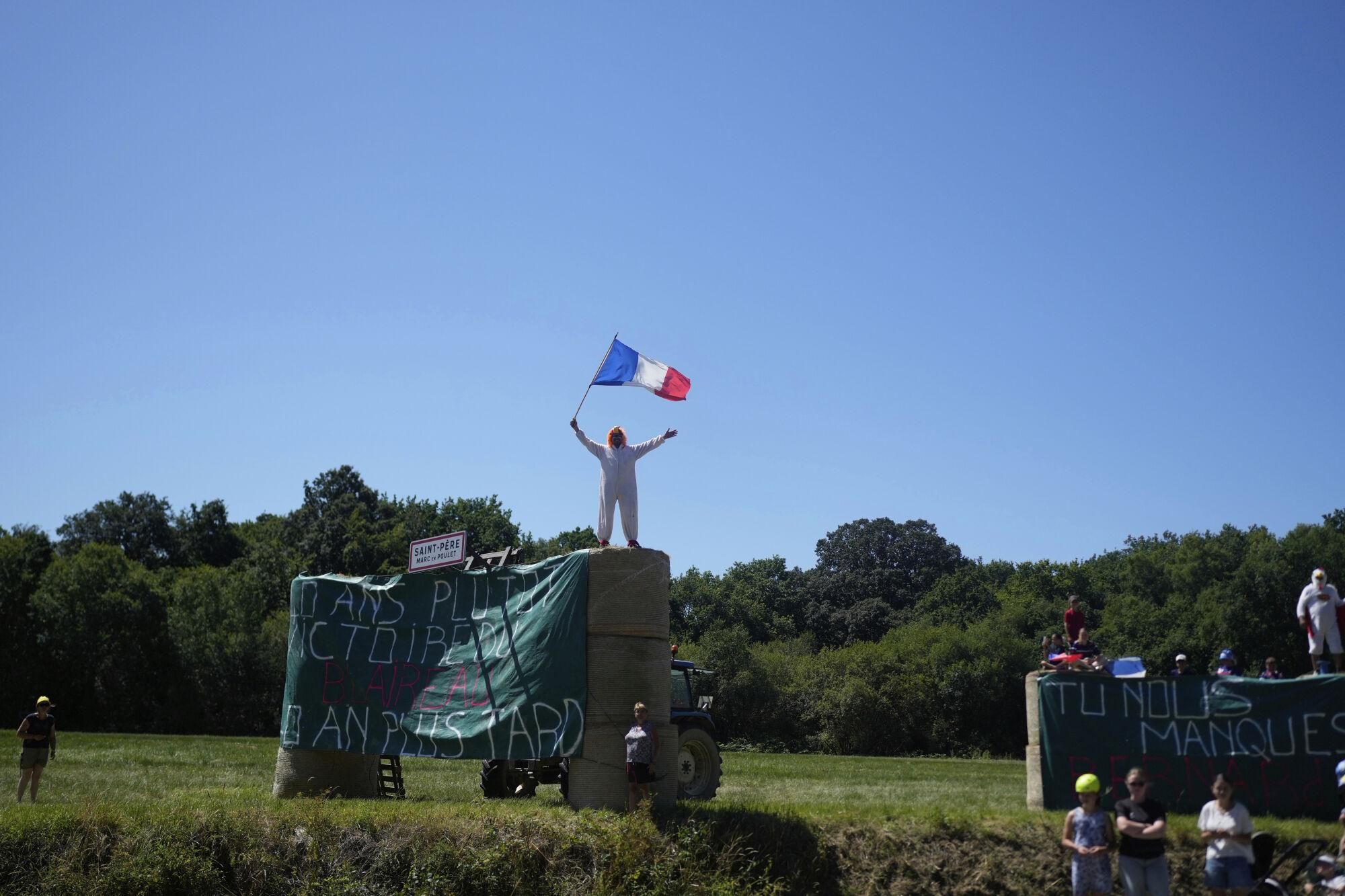 A fans holds a French flag during the seventh stage of the Tour de France cycling race over 197 kilometers (122.4 miles) with start in Saint-Malo and finish in Mur-de-Bretagne Guerledan, France, Friday, July 11, 2025. (AP Photo/Mosa'ab Elshamy)