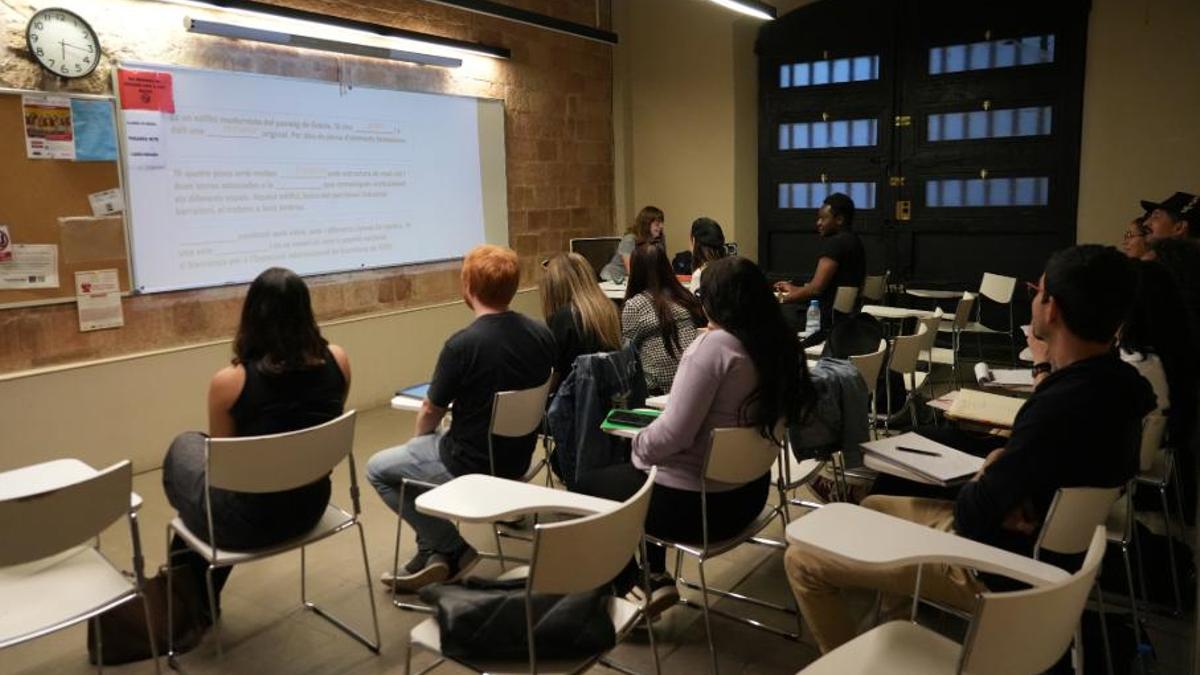 Diverses persones estudiant català en una classe del Consorci per a la Normalització Lingüística