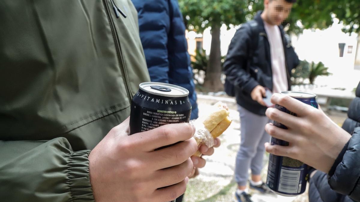 Jóvenes acompañan el bocadillo durante un recreo en el instituto con bebidas energéticas.