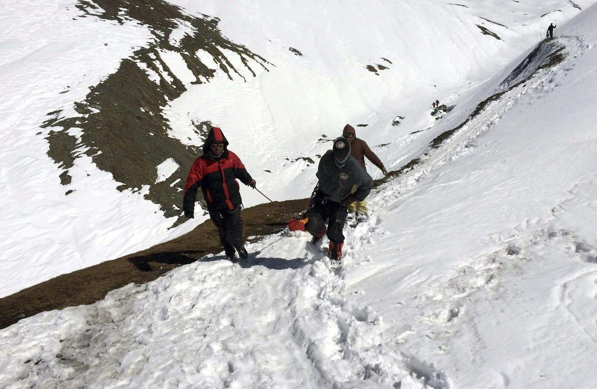 Tres soldados trasladan el cuerpo sin vida de un montañero en el paso Throung La del circuito de Annapurna en 2014.