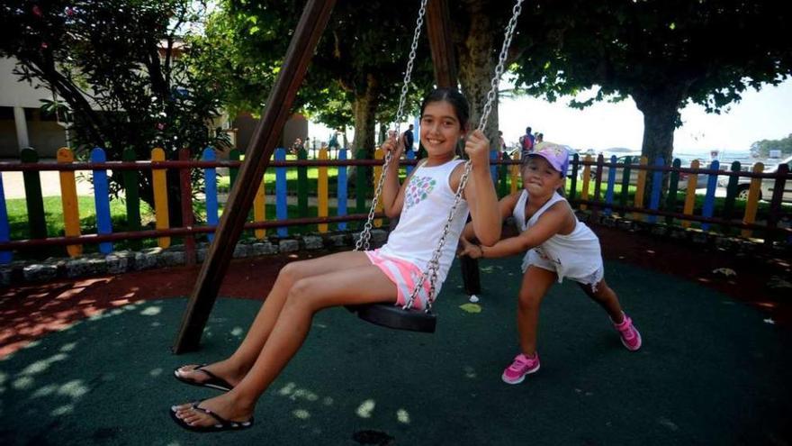 Niñas disfrutando de los columpios del parque infantil ubicado en la Alameda de Carril. // Iñaki Abella