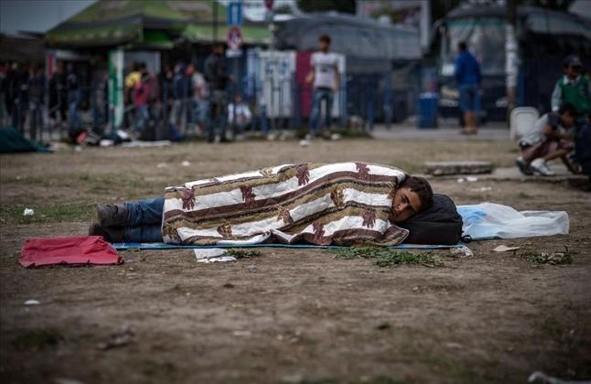 Un noi descansa a terra al parc on els immigrants han trobat allotjament temporal a Belgrad.