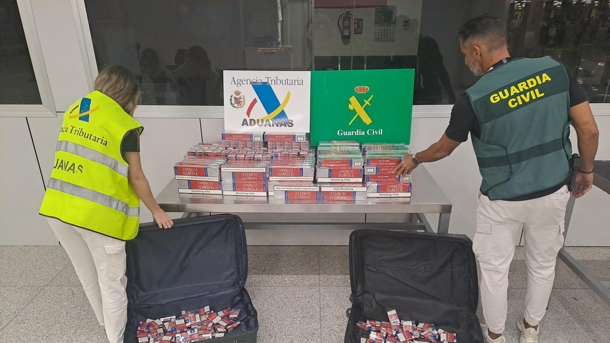 Agentes de la Guardia Civil y Aduanas examinan el tabaco intervenido en el aeropuerto.