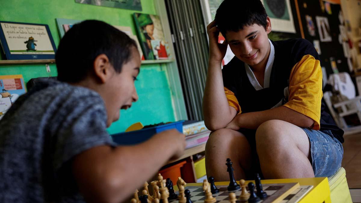 Achraf Labriyaj, de 9 años, juega al ajedrez con Eloy Moliner, de 12, durante el último día de clases en Pitarque, Teruel, una de las regiones menos pobladas de la Unión Europea. Achraf y su hermano Ismael se mudan con su familia y la escuela no podrá permanecer abierta con solo otros dos estudiantes. 