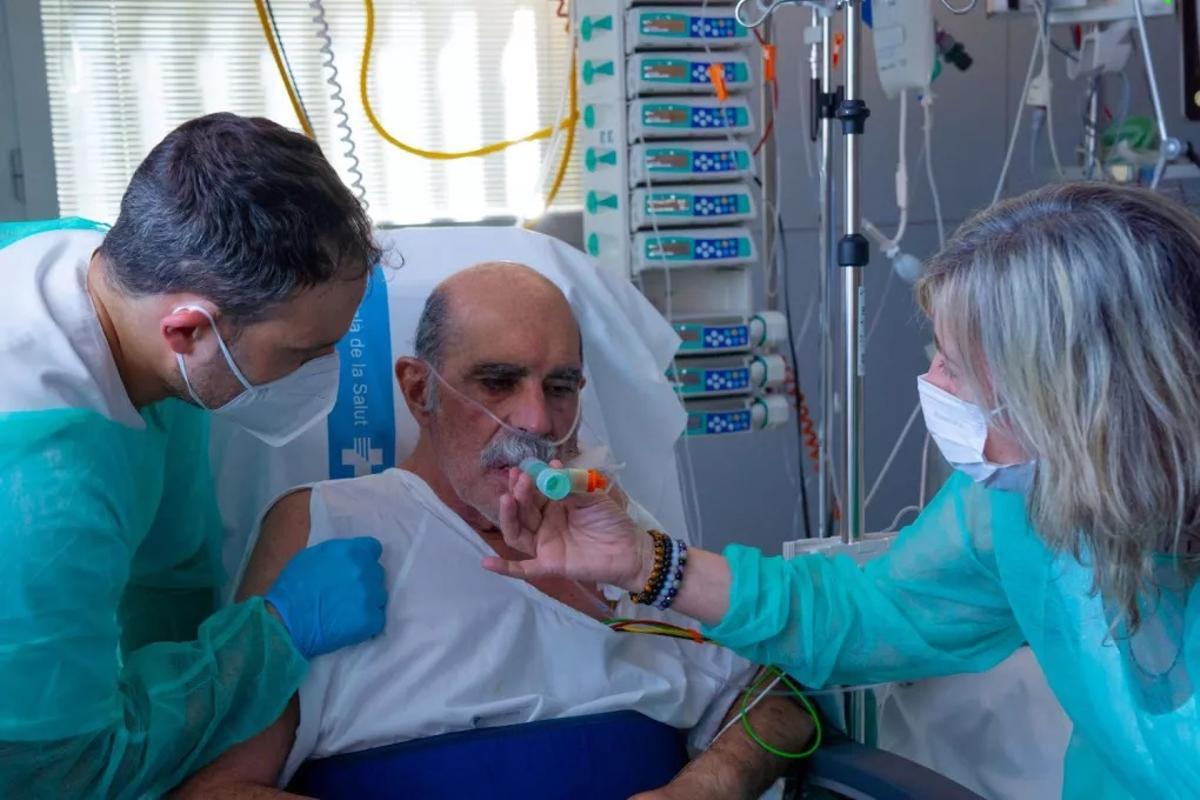 Una familiar ajuda un pacient a l'UCI.