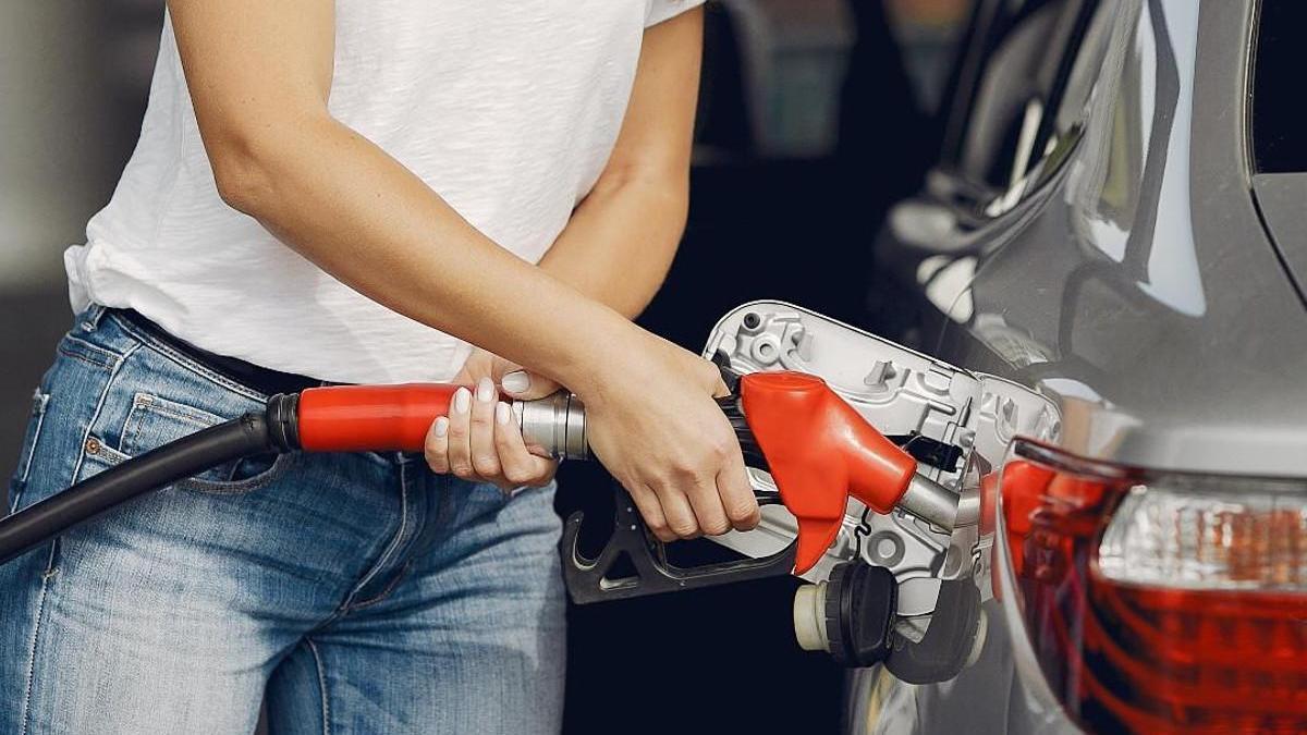 Una mujer pone gasolina.