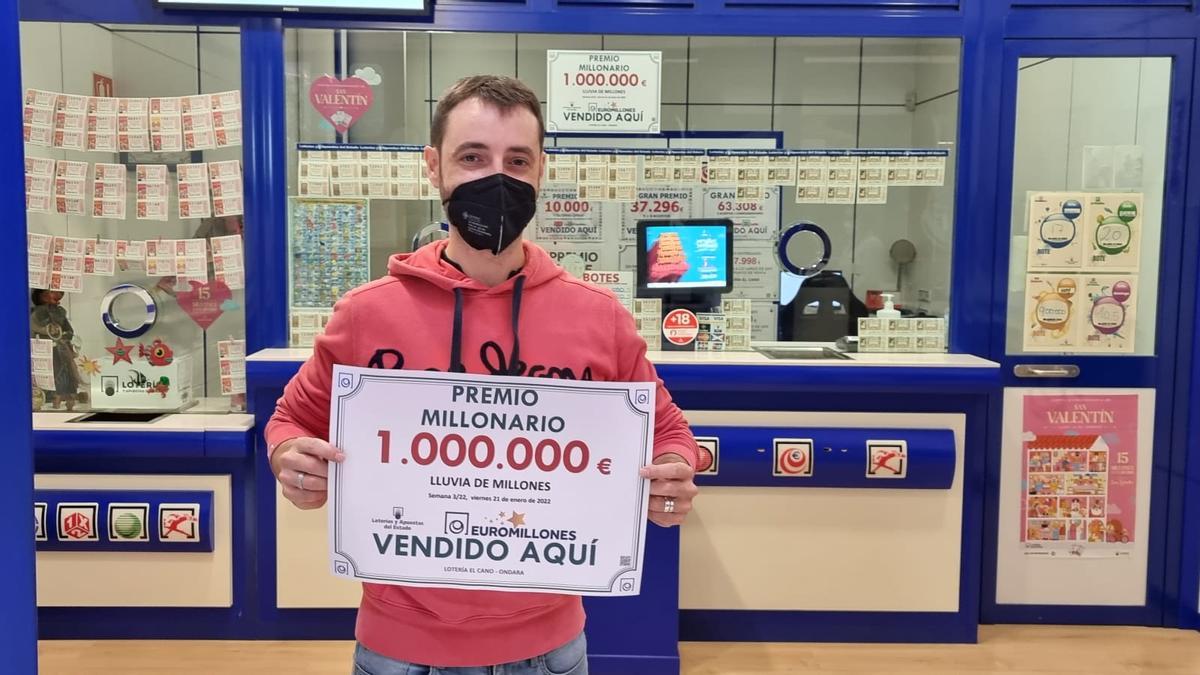 Juan Pablo Cano, de la administración del centro comercial de Ondara, posa con el cartel del premio millonario