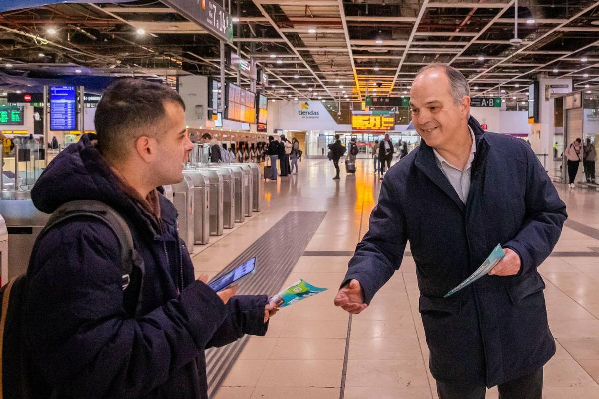 El secretario general de Junts, Jordi Turull, entregando un folleto de la campaña impulsada por el partido para denunciar el servicio de Rodalies de Catalunya