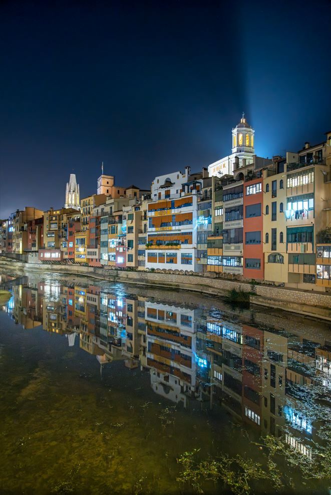 Imatge nocturna de les cases de l’Onyar, amb la Catedral i Sant Feliu al fons.