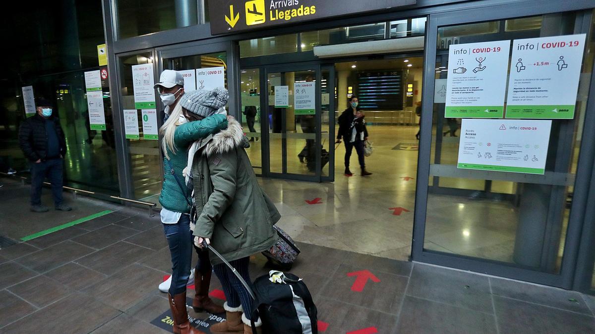 Familiares y amigos de los pasajeros llegados desde Manchester a València se abrazan a la salida de la sala de llegadas del aeropuerto de Manises, ayer.  | FF.CALABUIG